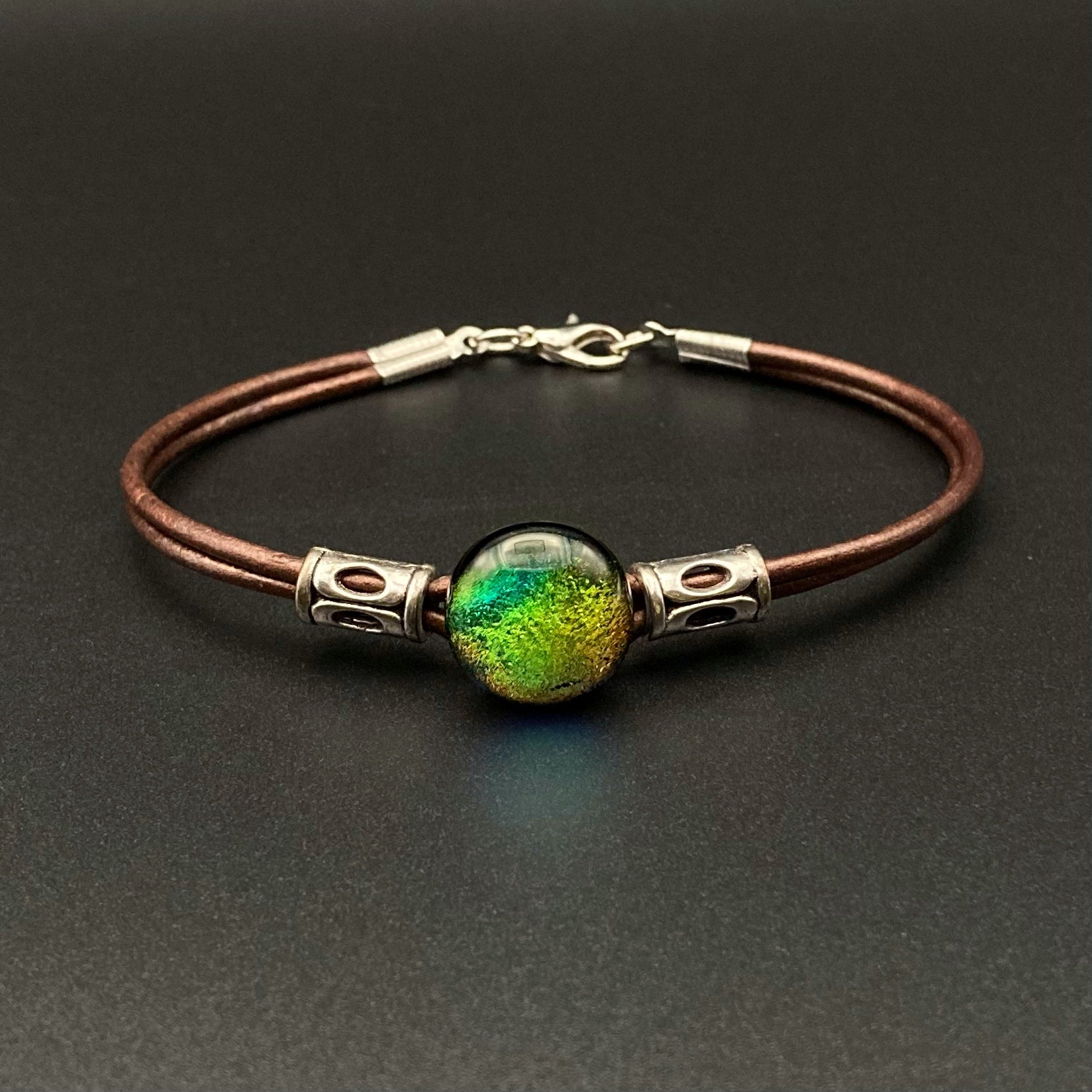 Metallic brown leather bracelet with a round green dichroic glass with metal beads, by 3DGlass Designs.
