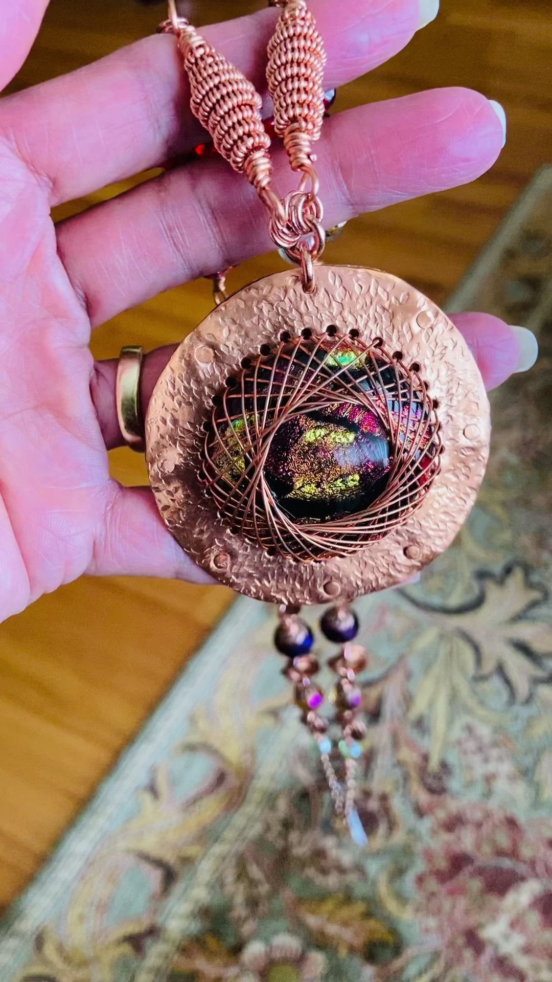 Video of hand holding long beaded necklace with a copper and dichroic glass pendant, by 3D Glass Designs.