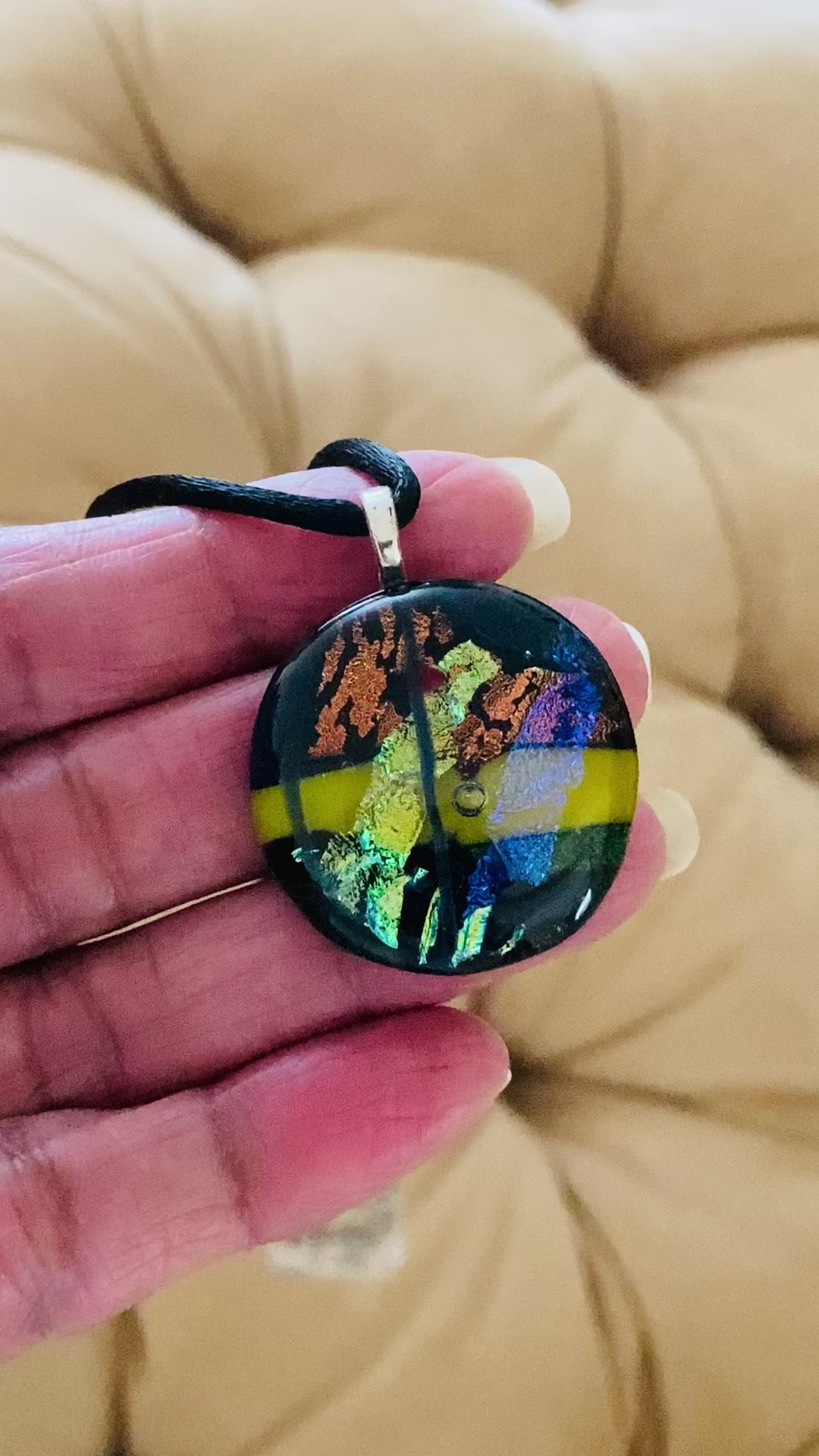 Video of hand holding multicolor fused glass pendant necklace, by 3D Glass Designs.