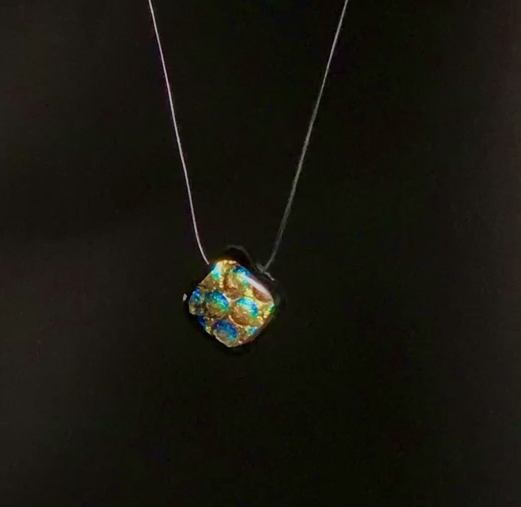 Diamond-shaped dichroic glass rotating against a black background, by 3D Glass Designs.